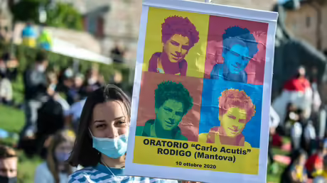 Eine junge Frau hält eine Fahne mit der Aufschrift "Oratorio "Carlo Acutis" Rodigo (Mantova) 10 ottobre 2020" vor der Basilika San Francesco anlässlich der Seligsprechung von Carlo Acutis / © Stefano Dal Pozzolo/Romano Siciliani (KNA) Eine junge Frau hält eine Fahne mit der Aufschrift "Oratorio "Carlo Acutis" Rodigo (Mantova) 10 ottobre 2020" vor der Basilika San Francesco anlässlich der Seligsprechung von Carlo Acutis / © Stefano Dal Pozzolo/Romano Siciliani (KNA)