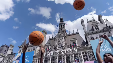Frankreich, Paris: Kinder spielen in einer Fanzone Basketball vor dem Hotel de Ville oder Rathaus, das für die Olympischen Sommerspiele dekoriert ist. / © David Goldman (dpa) Frankreich, Paris: Kinder spielen in einer Fanzone Basketball vor dem Hotel de Ville oder Rathaus, das für die Olympischen Sommerspiele dekoriert ist. / © David Goldman (dpa)