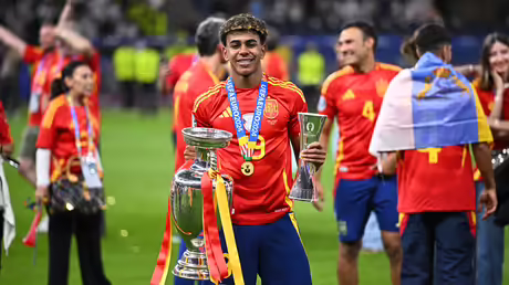 Spaniens Lamine Yamal jubelt mit der Trophäe und der Auszeichnung als bester Jungspieler nach dem Sieg im Finale der Fußballeuropameisterschaft. / © Tom Weller (DR) Spaniens Lamine Yamal jubelt mit der Trophäe und der Auszeichnung als bester Jungspieler nach dem Sieg im Finale der Fußballeuropameisterschaft. / © Tom Weller (DR)