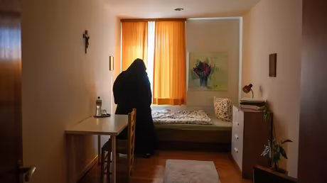 Eine Ordensfrau richtet die Decke in einem Zimmer für Gäste im Benediktinerinnenkloster Sankt Katharina von Siena, am 8. September 2023 in Düsseldorf / © Julia Steinbrecht (KNA) Eine Ordensfrau richtet die Decke in einem Zimmer für Gäste im Benediktinerinnenkloster Sankt Katharina von Siena, am 8. September 2023 in Düsseldorf / © Julia Steinbrecht (KNA)